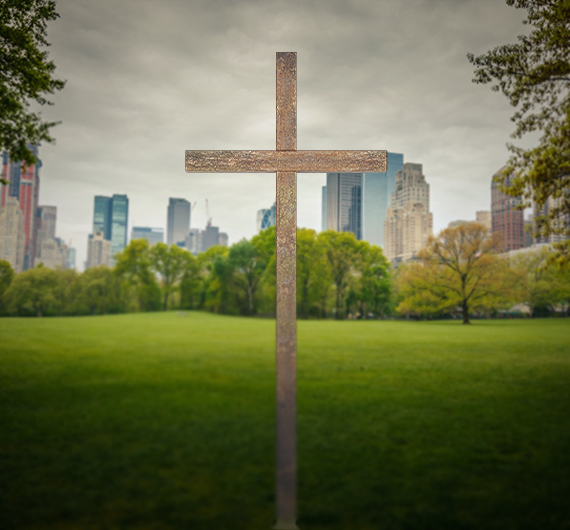 Cross overlooking a green landscape
